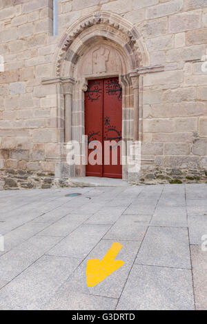 La Galizia, Spagna: tipica freccia gialla segnando il Camino Francés su la Rúa Maior vicino la Iglesia San Salvador. Foto Stock