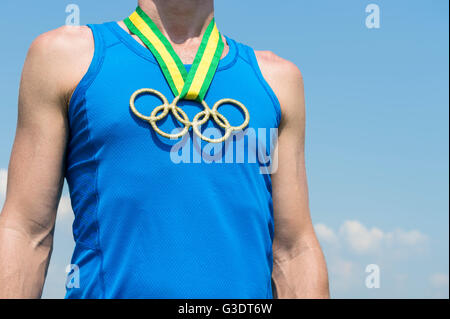 RIO DE JANEIRO - MARZO 20, 2016: atleta sta indossando gli anelli olimpici medaglia d oro appeso dal Brasile i colori del nastro. Foto Stock