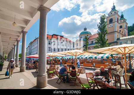 Ljubljana, Slovenia - 7 giugno 2016 persone a passeggiare e a fare shopping a Lubiana il mercato centrale, la chiesa di San Nicola in background Foto Stock