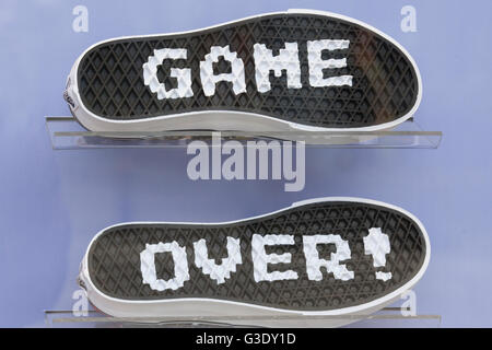 Visualizzazione in una finestra del negozio sneakers con le parole "game over' scritta sul suole Foto Stock