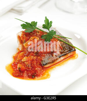 Frittura di filetto di trota con un pomodoro, cipolla e salsa di aglio. Foto Stock