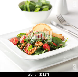 Una insalata di spinaci con pomodorini, noci, formaggio di capra e aceto balsamico. Foto Stock