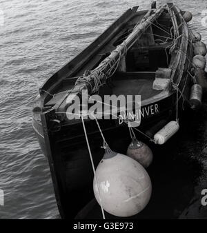 Un solitario barca ormeggiata nei pressi del porto (bianco e nero) Foto Stock