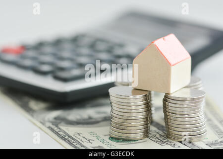 Casa il concetto di proprietà - un modello di casa su una pila di monete Foto Stock