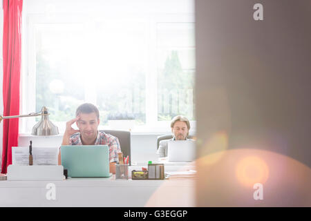 Imprenditore creativo lavorando al computer portatile in ufficio Foto Stock