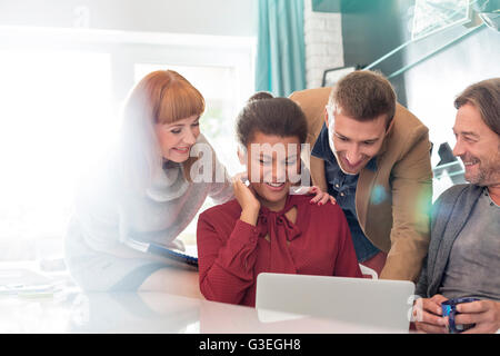 Azienda creativa persone condividendo laptop in riunione Foto Stock