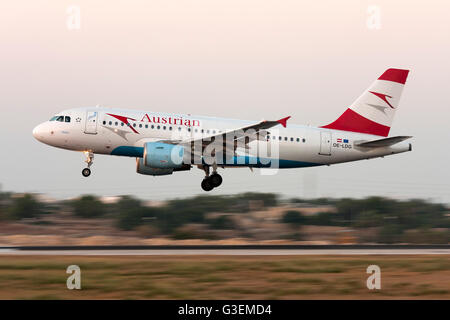 Austrian Airlines (Tyrolean Airways) Airbus A319-112 pista di atterraggio 32, appena dopo il tramonto. Foto Stock