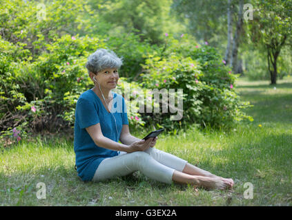 Senior sorridente Donna che utilizza il suo computer tablet. Foto Stock