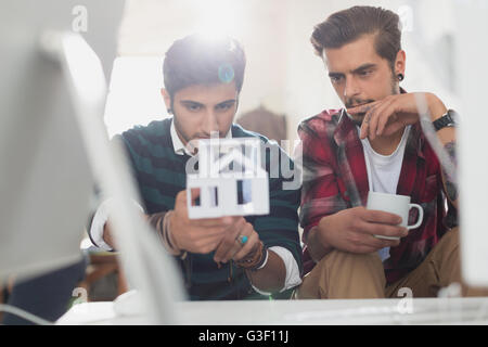 Giovani architetti maschio esaminando il modello della casa Foto Stock