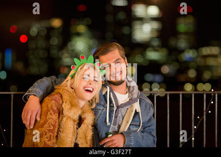 Ritratto sorridente coppia giovane godendo notturna Partito sul tetto Foto Stock