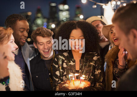 Amici celebrare la giovane donna il compleanno con torta e candele Foto Stock