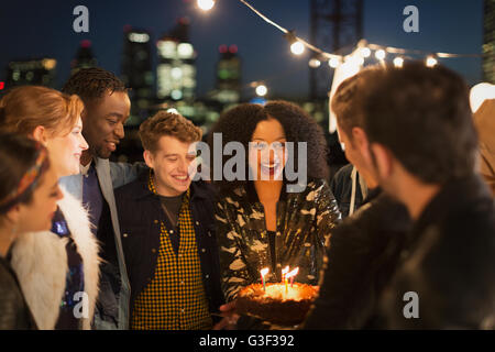 Giovani amici festeggia il compleanno in parte sul tetto Foto Stock