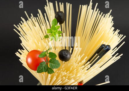 Materie spaghetti con pomodoro e olive poste in forma a spirale pronti per la cottura Foto Stock