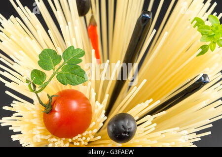 Materie spaghetti con pomodoro e olive poste in forma a spirale pronti per la cottura Foto Stock