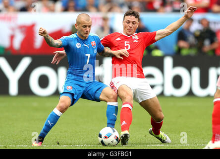 La Slovacchia di Vladimir Weiss e il Galles James Chester (destra) battaglia per la sfera durante UEFA EURO 2016, gruppo B corrispondono allo Stade de Bordeaux Bordeaux. Foto Stock