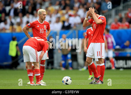 Il Galles Aaron Ramsey (posteriore, a sinistra) e il Galles Gareth Bale (destra) appaiono sconsolato come essi attendi per riavviare la partita dopo che la Slovacchia abbia Ondrej Duda (non in foto) punteggi il suo lato del primo obiettivo del gioco durante UEFA EURO 2016, gruppo B corrispondono allo Stade de Bordeaux Bordeaux. Foto Stock