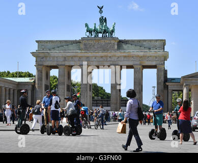 I turisti su Segways accanto a pedoni presso la Porta di Brandeburgo a Berlino, Germania, 10 giugno 2016. Foto: Jens KALAENE/dpa Foto Stock