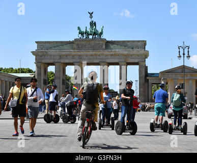 I turisti su Segways accanto a pedoni presso la Porta di Brandeburgo a Berlino, Germania, 10 giugno 2016. Foto: Jens KALAENE/dpa Foto Stock