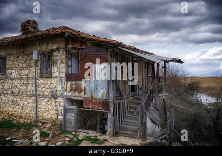 Vecchio e gli edifici abbandonati, in Agios Achilios isola, laghi Prespes, Grecia, in un giorno di pioggia Foto Stock