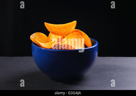 Patatine fritte in un recipiente isolato su nero Foto Stock
