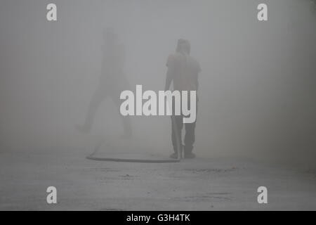 Lalitpur, Nepal. Il 25 giugno, 2016. Un lavoratore flutti polvere per strada concreta in Lalitpur, Nepal, Sabato 25 Giugno 16. © Skanda Gautam/ZUMA filo/Alamy Live News Foto Stock