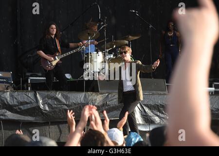 Cantautore britannico e il pianista Tom Odell warlking attraverso la pioggia di fronte a migliaia di tifosi durante il primo giorno al Southside Festival in Neuhausen ob Eck, Germania, 24 giugno 2016. Foto: FELIX KAESTLE/dpa Foto Stock