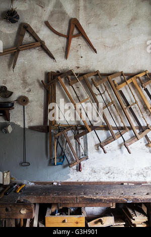 Le vecchie seghe appesi al muro in un workshop Foto Stock