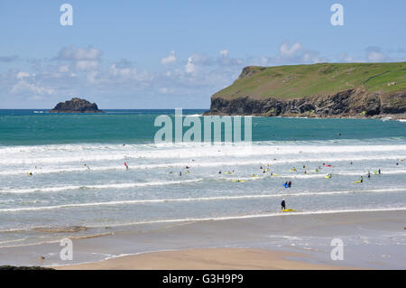 Polzeath Beach - marea - bianco sormontato rulli - surfers - blu del mare e del cielo - sfondo Pentire testa Cornovaglia Foto Stock
