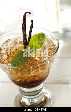 Ribes nero e vaniglia mojito fatto con la menta, il succo di lime, lo zucchero di canna ghiaccio tritato, rum e liquore di ribes nero. Foto Stock