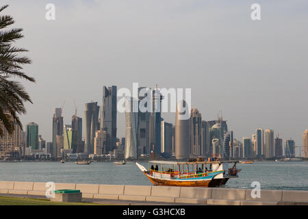 Doha West Bay visto da Al Corniche. Barca Dhow con il Qatar in donne Abayas in primo piano. Foto Stock