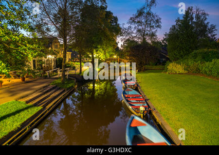 Giethoorn, Paesi Bassi. Giethoorn Sterline o agli scommettitori, punting Barche in affitto in Dorpsgracht o villaggio Canal al crepuscolo. Foto Stock