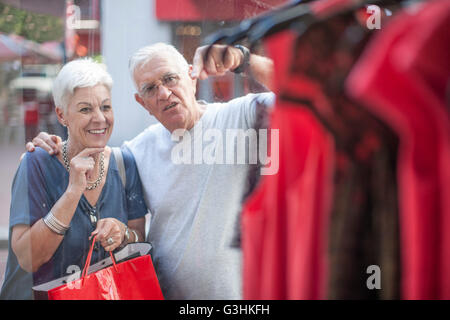 Coppia senior shopping per vestire in città vetrina Foto Stock