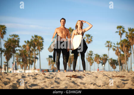 Navigare in coppia con tavole da surf guardando fuori dalla spiaggia di Venice, California, Stati Uniti d'America Foto Stock