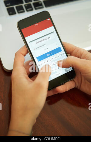 Womans mani tenendo la firma dello smartphone a internet banking Foto Stock