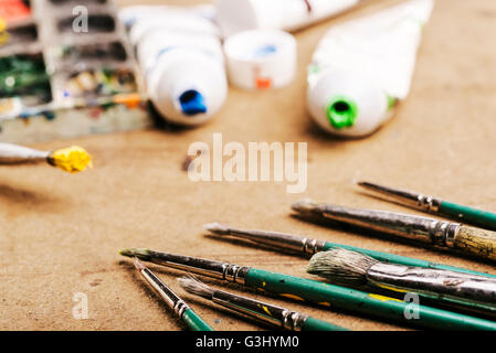 Pennelli e colori posa su una tabella di studio. Foto Stock