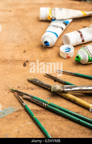 Pennelli e colori posa su una tabella di studio. Foto Stock