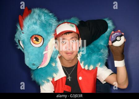 Cosplayers Henry Woo, 26 (anteriore) vestita come Trainer rosso e James Scollon, 29 vestiti come Feraligatr, sia dal gioco Pokemon, come gli appassionati di giochi per computer frequentare il weekend long play Expo presso la Braehead Arena, Glasgow. Foto Stock