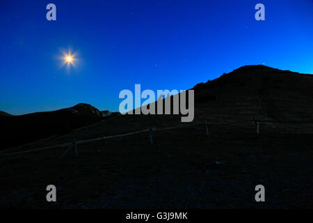 In montagna la notte con la luna sul cielo Foto Stock