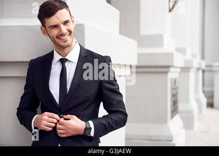 Allegro uomo appoggiato sulla parete Foto Stock