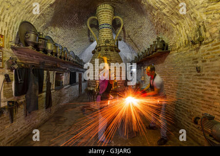 Fabbro martellare il ferro a Bukhara, Uzbekistan. Foto Stock