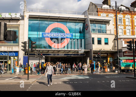 Persone in attesa o in piedi davanti all'entrata della Brixton stazione della metropolitana nella zona sud di Londra Foto Stock