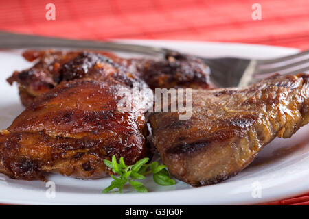 Uno serve cucina di carne di maiale chop sulla piastra bianca con forca Foto Stock