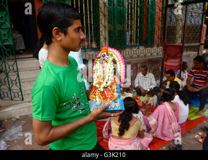 Kolkata, India. Xiv Apr, 2016. Un uomo bengalese tenere Dea Laxmi idolo dopo aver eseguito puja alla Kali Ghat tempio durante il Nuovo Anno. Il bengalese festeggia il nuovo anno 1423 in tutto il mondo dalla mattina. © Saikat Paolo/Pacific Press/Alamy Live News Foto Stock
