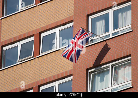 Un Union Jack appesa da una finestra in un blocco di appartamenti. Foto Stock