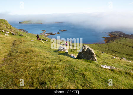 Famiglia a piedi in discesa verso l'Oceano Atlantico a Garrafad bay, sulla costa nordorientale dell'Isola di Skye, Ebridi Interne, Scotland, Regno Unito, Europa Foto Stock