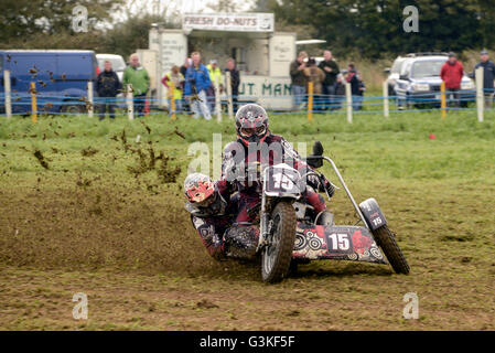 Moto sidecar team una curva a erba via evento racing con gli spettatori a guardare Foto Stock