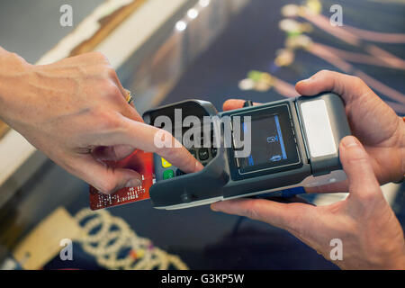 Angolo di alta vista ritagliata della womans mano con chip e pin macchina Foto Stock