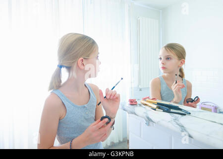 Camera da letto immagine speculare della ragazza con il make up pennello staring a se stessa Foto Stock