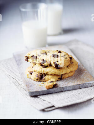 Tre i biscotti al cioccolato con bicchiere di latte Foto Stock