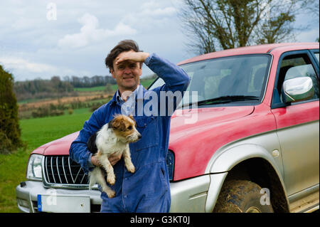 Ritratto di contadino che trasportano cane Foto Stock